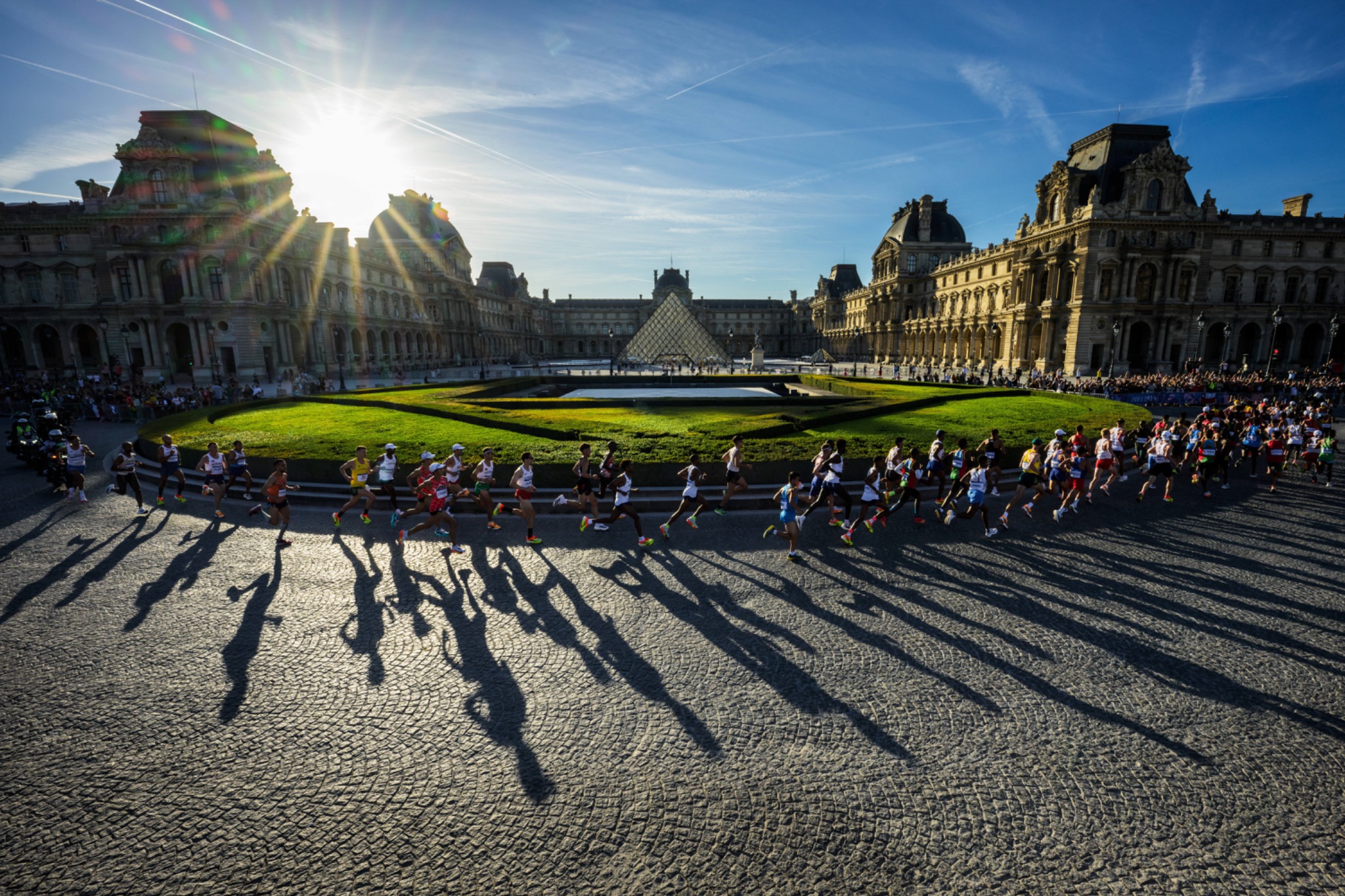 Corredores da HOKA Semi de Paris diante do Louvre, em Paris, França