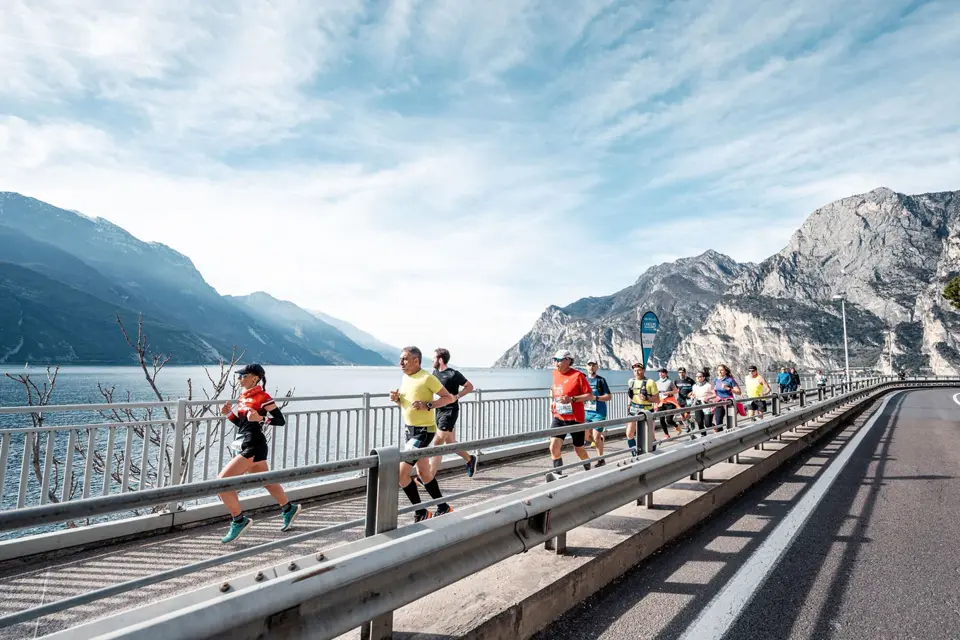 Corredores da Garda Trentino Half Marathon entre o Lago de Garda e as montanhas italianas