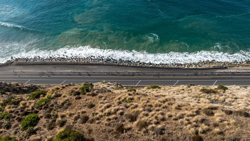 Corredores da Run Malibu Half Marathon pela costa de Malibu, Estados Unidos
