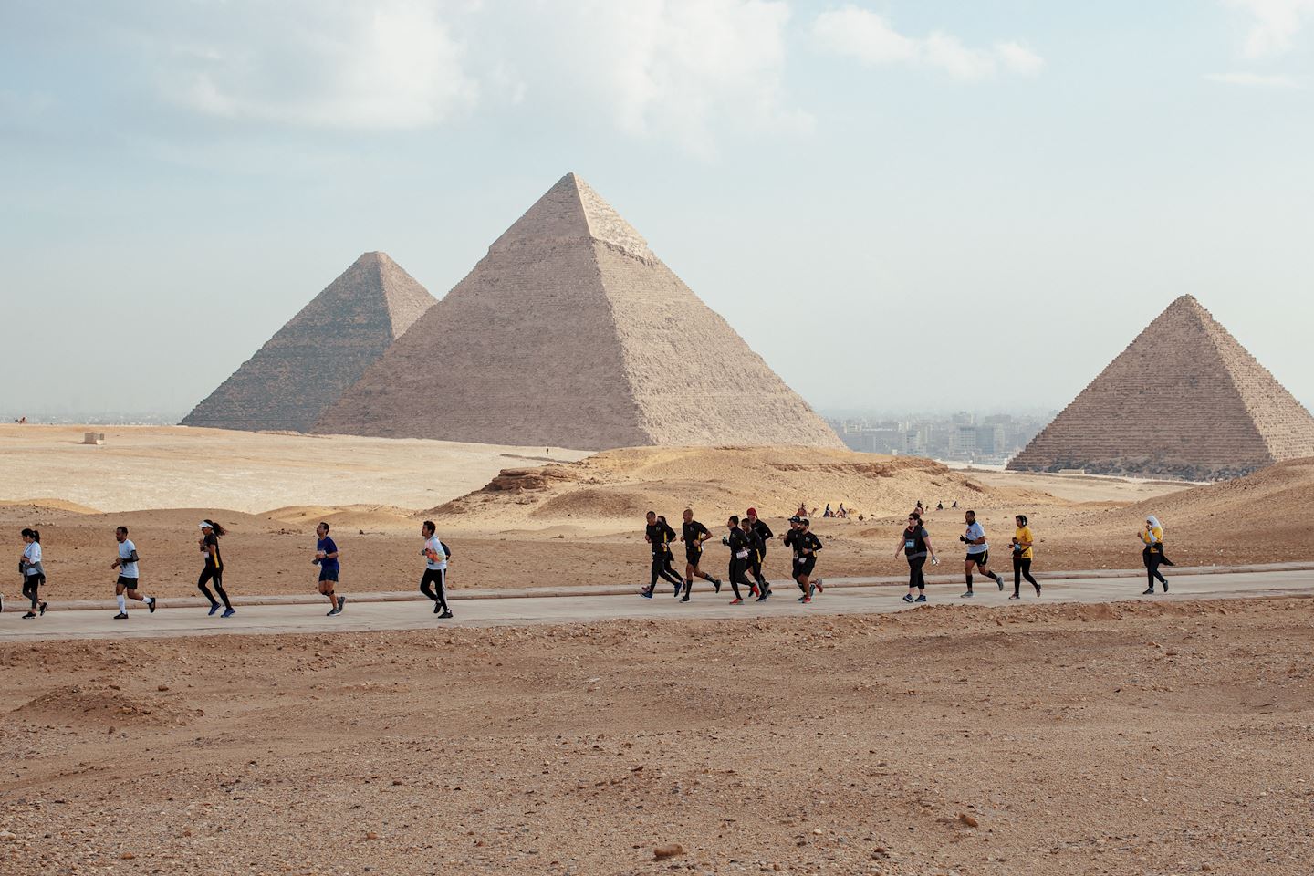 Corredores da Pyramids Half Marathon com as Pirâmides de Gizé ao fundo